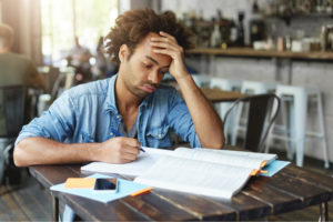 A college student experiences headaches while studying due to prolonged Adderall addiction. Treatment can provide relief from the symptoms of Adderall abuse.